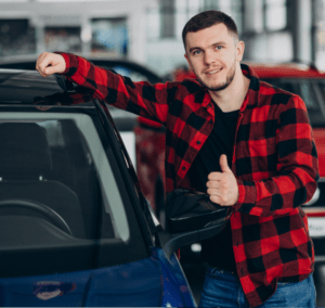Man giving thumbs up at car dealer