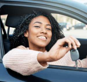 Young woman sitting in car holding car keys