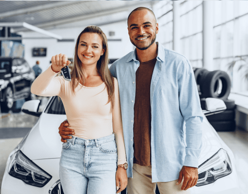 Woman and man with keys to a new car